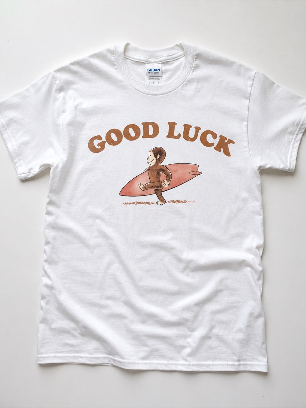 Gildan White Tee with Brown 'Good Luck' Monkey and Pink Surfboard Graphic